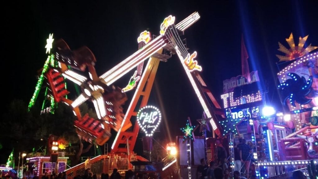 Atracciones infantiles iluminadas en el Recinto Ferial del Parque de la Marina de Sanse
